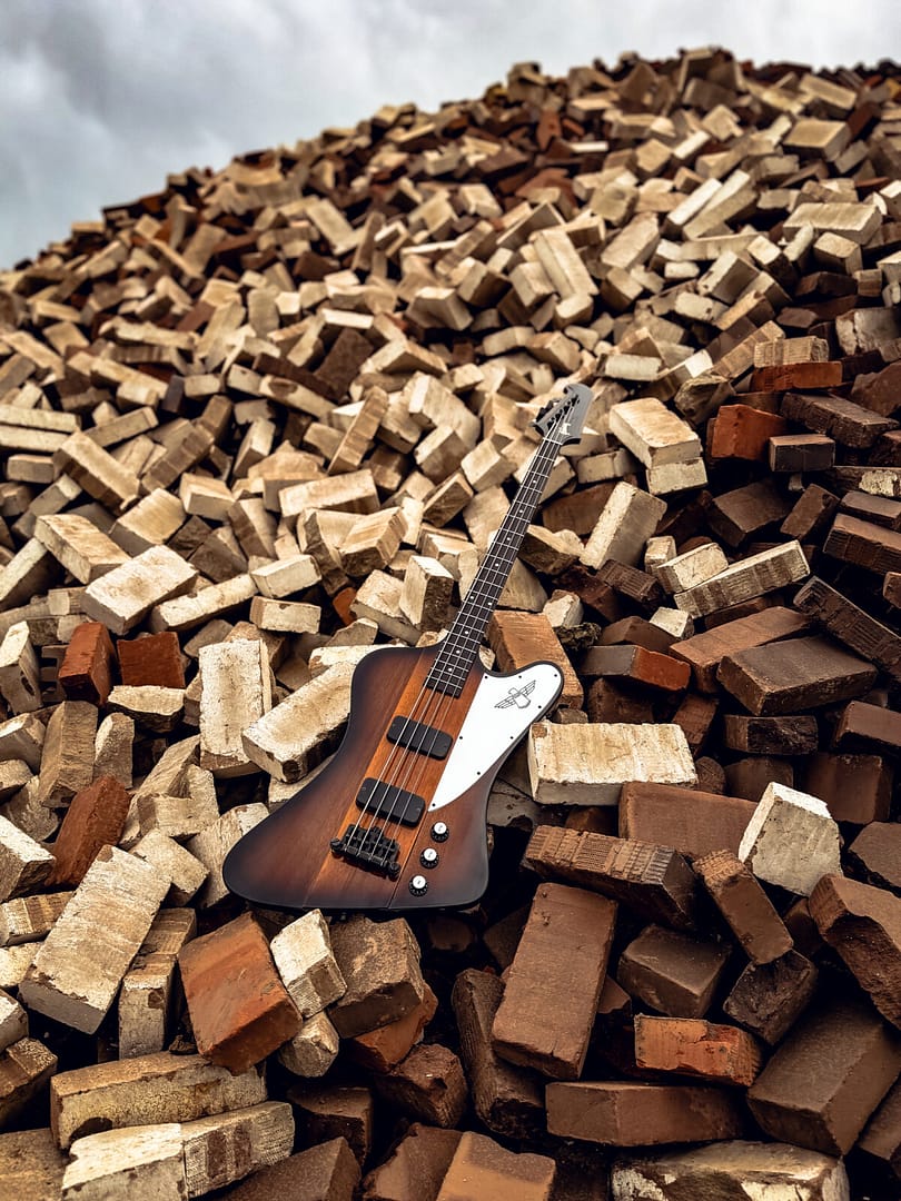 Bass guitar photography: Gibson Thunderbird bass in a large pile of bricks